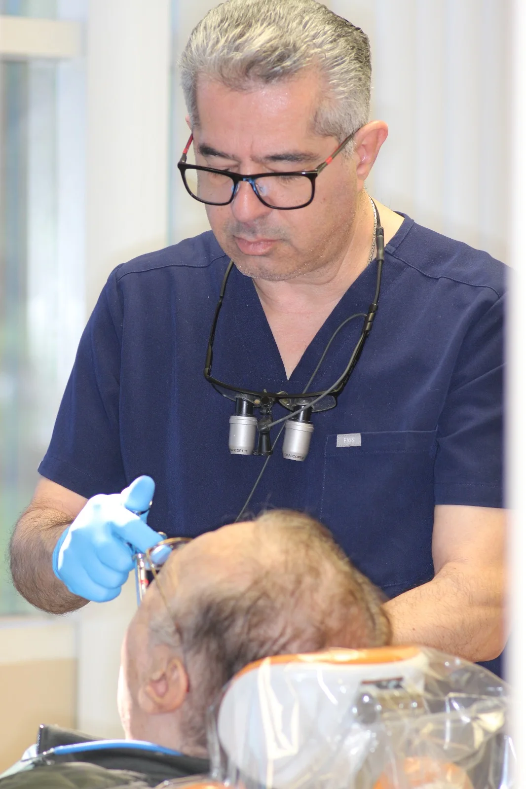Dr. Tafreshi with surgical loupes during an implant placement